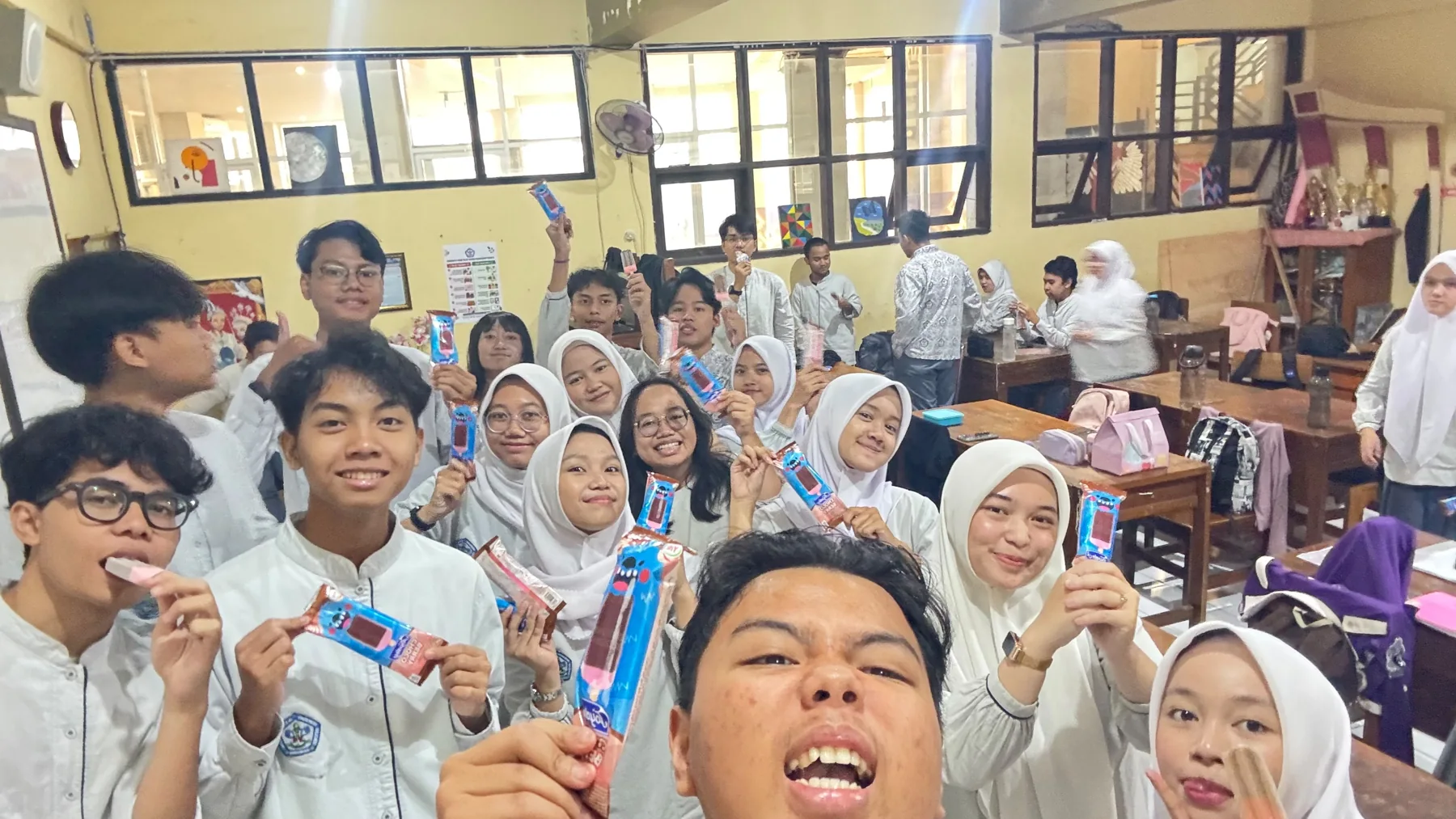 Momen makan es krim bersama di ruang kelas.